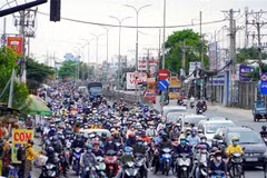 Người dân từ miền Tây về Thành phố Hồ Chí Minh rất đông, khiến Quốc lộ 1 đoạn qua cầu Bình Điền di chuyển khó khăn. (Ảnh: Tiến Lực/TTXVN)