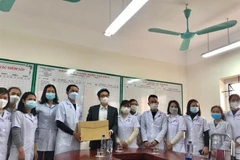 Phó Thủ tướng Vũ Đức Đam tặng quà cho cán bộ, nhân viên y tế Trạm y tế lưu động (cơ sở thu dung F0) tại Trường Mầm non xã Chu Phan (huyện Mê Linh). (Ảnh: Tuyết Mai/TTXVN)
