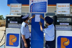 Lực lượng quản lý thị trường tỉnh Ninh Thuận dán thông báo đường dây nóng tiếp nhận thông tin phản ánh hành vi vi phạm trong hoạt động kinh doanh xăng dầu. (Ảnh: Công Thử/TTXVN)