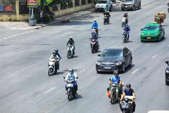 Người dân di chuyển dưới trời nắng nóng tại Hà Nội. (Ảnh: Tuấn Anh/TTXVN)