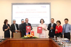 Tổng giám đốc Thông tấn xã Việt Nam Vũ Việt Trang và Chủ tịch Thông tấn xã Mỹ Latinh Prensa Latina Luis Enrique Gonzalez Acosta trao văn bản ký kết hợp tác giữa hai cơ quan. (Ảnh: Phương Hoa/TTXVN)