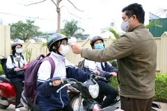 Học sinh tại trường THPT chuyên Sơn La được kiểm tra thân nhiệt trước khi vào lớp. (Ảnh: Hữu Quyết/TTXVN)
