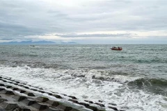 Lực lượng biên phòng đang tìm kiếm người mất tích trong vụ chìm canô du lịch tại Cửa Đại. (Ảnh: TTXVN)