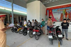 Nhóm thanh thiếu niên và phương tiện bị bắt giữ. (Ảnh: TTXVN phát)
