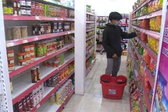 Người dân mua hàng tại một siêu thị ở thủ đô Vientian, Lào. (Ảnh: Phạm Kiên/TTXVN)