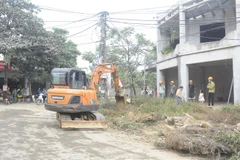 Huyện Ba Vì (Hà Nội) huy động phương tiện cơ giới thực hiện cưỡng chế tháo dỡ, cây, tường rào...trong phạm vi giải phóng mặt bằng. (Ảnh Mạnh Khánh/TTXVN)