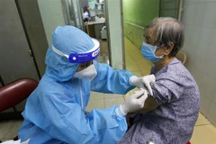 Các y bác sỹ tiêm vaccine cho người trên 65 tuổi, người có bệnh nền tại Trung tâm y tế phường 11, quận Phú Nhuận. (Ảnh: Thanh Vũ - TTXVN)
