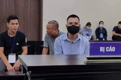 Bị cáo Việt (đeo khẩu trang, áo xanh) lừa đảo chạy vào ngành công an. (Nguồn: laodong.vn)