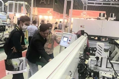 Khách tham quan tìm hiểu về thiết bị chế biến gỗ tại VietnamWood 2022 và Funitec 2022. (Ảnh: Xuân Anh/TTXVN)