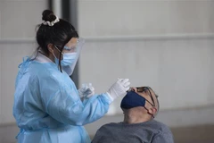  Nhân viên y tế lấy mẫu xét nghiệm COVID-19 cho người dân tại Nicosia, Cyprus. (Ảnh: THX/TTXVN)