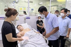 Ông Hồ Đại Dũng, Phó Chủ tịch UBND tỉnh Phú Thọ thăm hỏi, động viên gia đình người gặp nạn đang được cấp cứu tại bệnh viện. (Ảnh: Trung Kiên/TTXVN)