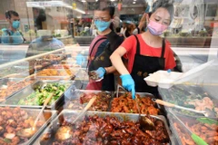 Nhân viên nhà hàng Kitty Cha đang phục vụ khách hàng những hộp cơm hai món giá rẻ. (Nguồn: thesundaily.my)