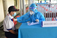 Khám sàng lọc cho học sinh trong độ tuổi trước khi tiêm vaccine phòng COVID-19. (Ảnh: Hữu Chí/TTXVN)