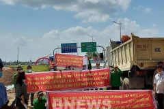 Nhóm người căng băngrôn yêu cầu thanh toán tiền vật liệu. (Nguồn: Bnews)