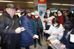 Cán bộ Đại sứ quán Việt Nam tại Ba Lan hỗ trợ thủ tục lên máy bay cho kiều bào sơ tán từ Ukraine. (Ảnh: Hồng Kỳ/TTXVN)
