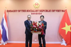 Đại sứ Lào tại Thái Lan Khamphan Anlavan trao lẵng hoa chúc mừng Quốc khánh Việt Nam. (Ảnh: Đỗ Sinh/TTXVN)