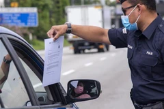 Cảnh sát kiểm tra các phương tiện để phòng dịch COVID-19 tại Petaling Jaya, Malaysia. (Ảnh: THX/TTXVN)