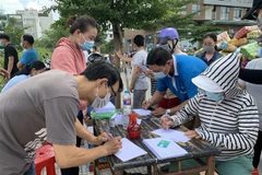 Người dân khu phố 1, phường 15, quận Gò Vấp khai báo y tế trước khi được lấy mẫu xét nghiệm COVID-19. (Ảnh: TTXVN phát)