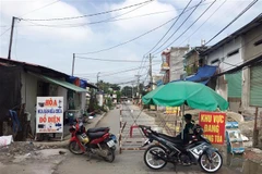 Lực lượng chức năng phong tỏa một đoạn đường TL19 (Khu phố 3B, phường Thạnh Lộc, Quận 12, Thành phố Hồ Chí Minh). (Ảnh: Tiến Lực/TTXVN)