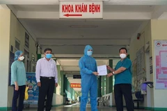 Giám đốc Bệnh viện phổi Đà Nẵng Lê Thành Phúc trao giấy chứng nhận xuất viện cho bệnh nhân. (Ảnh: Văn Dũng/TTXVN)