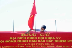 Lắp đặt Panô tuyên truyền tại khu vực bỏ phiếu số 5, xã Mường Giàng, huyện Quỳnh Nhai. (Ảnh: Quang Quyết/TTXVN)