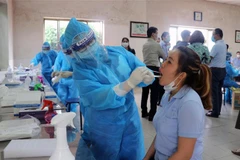 Nhân viên y tế lấy mẫu xét nghiệm cho công nhân làm việc tại các khu công nghiệp. (Ảnh: TTXVN phát)