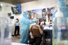 Lấy mẫu xét nghiệm COVID-19 tại Công Ty Cổ Phần Giày Vĩnh Yên, một doanh nghiệp ngoài khu công nghiệp. (Ảnh: Hoàng Hùng/TTXVN)