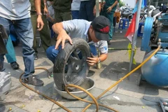 Vá lốp xe bị cán đinh. (Ảnh: Hải Âu/TTXVN)