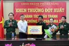Phó Chủ tịch Ủy ban Nhân dân thành phố Hồ Kỳ Minh (áo trắng) trao thưởng nóng cho cán bộ, chiến sỹ lực lượng phòng chống tội phạm ma túy Bộ đội biên phòng Đà Nẵng. (Ảnh: Trần Lê Lâm/Vietnam+)