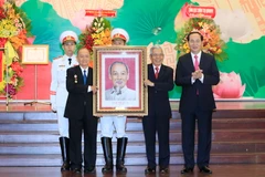 Chủ tịch nước Trần Đại Quang tặng bức chân dung Chủ tịch Hồ Chí Minh cho Ban Cơ yếu Trung ương cục miền Nam. (Ảnh: Nhan Sáng/TTXVN)