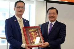 Bộ trưởng Bộ Tài chính Đinh Tiến Dũng trao quà lưu niệm cho Giám đốc FPT Japan Trần Đăng Hòa. (Ảnh: Thành Hữu-Gia Quân/Vietnam+)