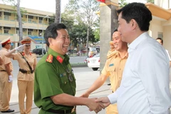 Ông Đinh La Thăng với cán bộ, chiến sỹ Phòng Cảnh sát giao thông đường bộ-đường sắt. (Ảnh: Thanh Vũ/TTXVN)