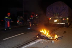 Cảnh sát Phòng cháy chữa cháy tham gia dập lửa tại hiện trường vụ tai nạn. (Ảnh: Nguyễn Dũng/TTXVN) 