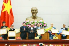 Thủ tướng Nguyễn Xuân Phúc tặng Bằng khen của Thủ tướng Chính phủ cho các gương mặt trẻ tiêu biểu năm 2016. (Ảnh: Thống Nhất/TTXVN)