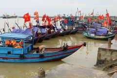 Ngư dân neo đậu tàu thuyền tránh bão dọc ven biển Cửa Hội sáng 16/7. (Ảnh: Thanh Tùng/TTXVN)
