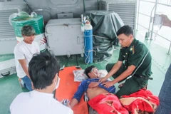 Quân y bộ đội biên phòng Sóc Trăng cấp cứu các ngư dân bị nạn trên biển. (Ảnh: Trung Hiếu/TTXVN)