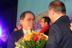 Thị trưởng Didier Guillaume đã tặng hoa Đại sứ Nguyễn Ngọc Sơn tại buổi lễ. (Ảnh: Bích Hà/Vietnam+)