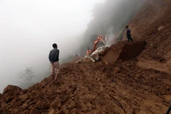 Đơn vị thi công khẩn trương khoan phá tảng đá, giải phóng mặt đường. (Ảnh: Phan Tuấn Anh/TTXVN)