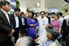 Bộ trưởng Nguyễn Thị Kim Tiến tiếp xúc với người bệnh để kiểm tra công tác chuyên môn tại Bệnh viện Đa khoa Xanh Pôn. (Ảnh: Dương Ngọc/TTXVN)