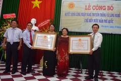 Trao Quyết định của UBND tỉnh Kiên Giang công nhận nghề truyền thống và làng nghề truyền thống chế biến nước mắm Phú Quốc. (Ảnh: Lê Sen/TTXVN)