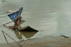 Chiếc phà chở xe tải và một số xe gắn máy chìm xuống sông Đồng Nai. (Ảnh: Sỹ Tuyên/TTXVN)