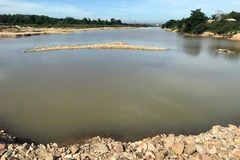 Con đập do doanh nghiệp làm giữa sông Đăk Bla để tích nước, hút cát. (Ảnh: Cao Nguyên/TTXVN)