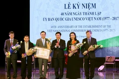 Phó Thủ tướng Phạm Bình Minh trao Bằng khen của Thủ tướng Chính phủ cho Uỷ ban Quốc gia UNESCO Việt Nam. (Ảnh: Nguyễn Dân/TTXVN)