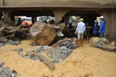 Thầy cô giáo và phụ huynh học sinh dọn dẹp đất đá vùi lấp tại Trường Tiểu học-Trung học cơ sở thị trấn Mù Cang Chải, Yên Bái. (Ảnh: Đinh Hữu Dư/TTXVN)