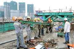 Công nhân thực hiện các công đoạn cuối của cầu đường sắt đô thị bắc qua sông Sài Gòn. (Ảnh: An Hiếu/TTXVN)