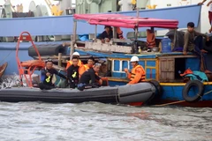 Tìm kiếm nạn nhân một vụ chìm sà lan. (Nguồn: TTXVN)