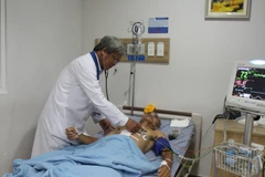 Bác sỹ Ngô Đức Đễ thăm khám cho bệnh nhân. (Ảnh: Lê Xuân/TTXVN)