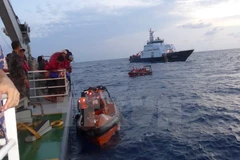 Các xuồng của Việt Nam cập mạn tàu Indonesia để đón ngư dân. (Ảnh: Đỗ Quyên/TTXVN)