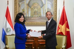 Đại sứ Việt Nam Đặng Xuân Dũng trao bản sao thư ủy nhiệm của Chủ tịch nước Trần Đại Quang cho quyền Bộ trưởng Ngoại giao Paraguay Terumi Matsuo de Claverol. (Ảnh: Diệu Hương/Vietnam+)