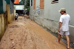 Bùn đất từ dự án FLC Hạ Long tràn xuống làm người dân đi lại khó khăn. (Ảnh: Nguyễn Hoàng/TTXVN)